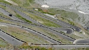 winding mountain road with cyclists and car