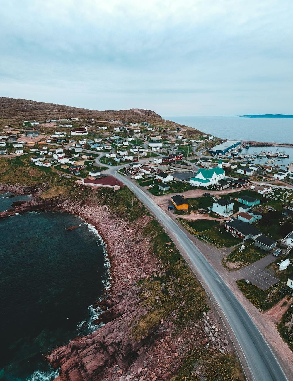 coastal town near road and sea against cloudy sky