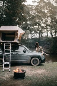 a woman sitting on the hood of the car