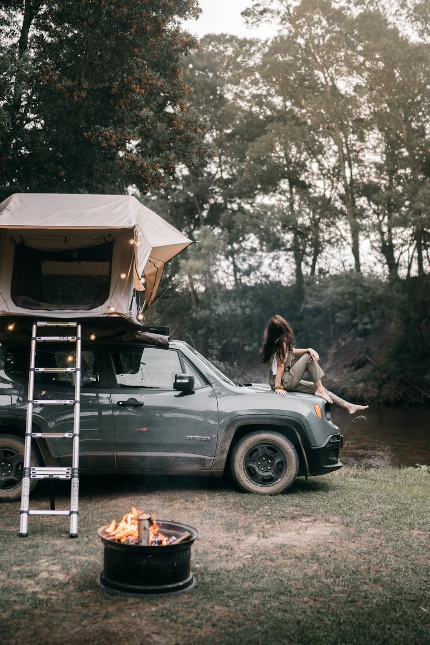 a woman sitting on the hood of the car