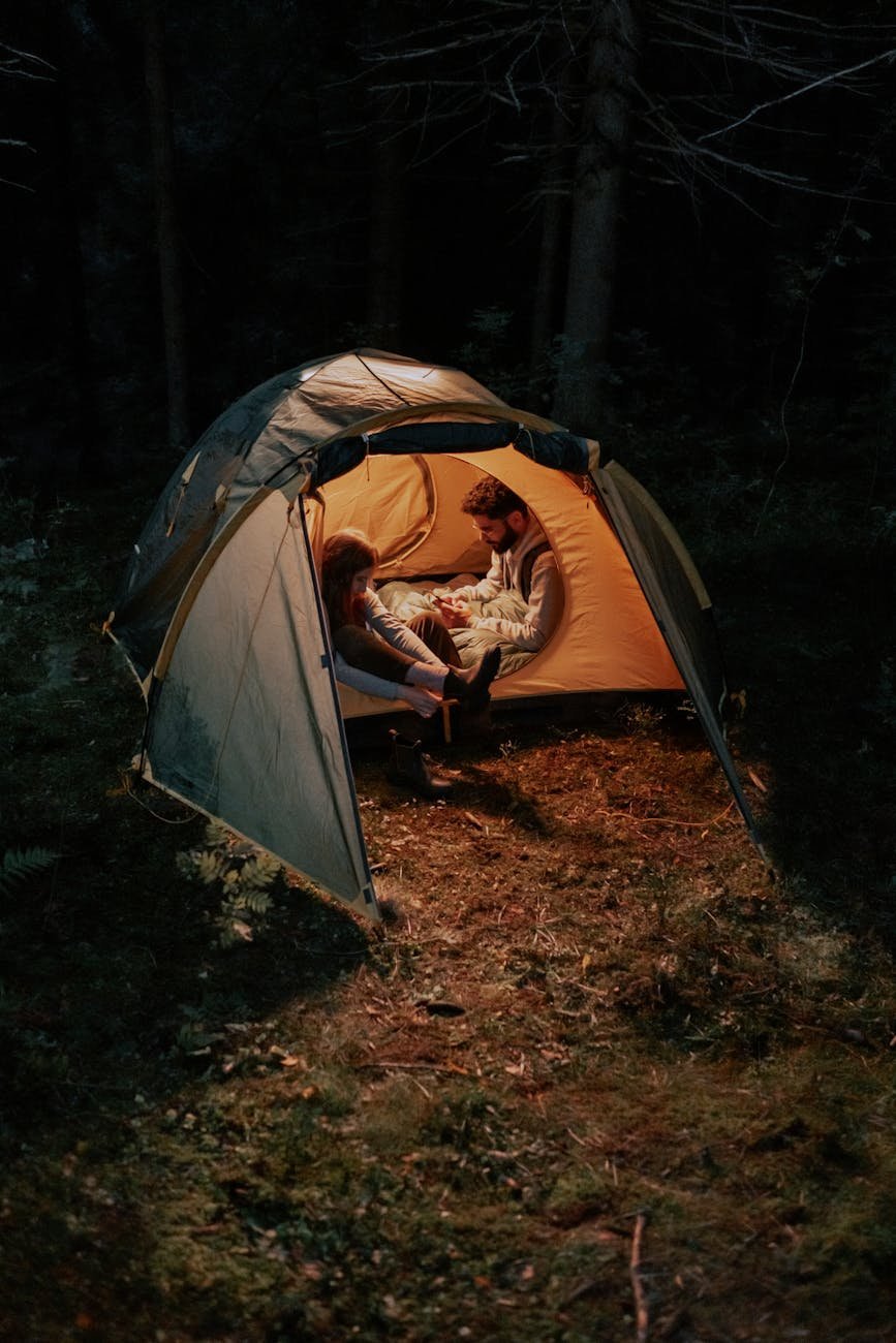 man and woman sitting inside a tent