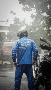 photo of a biker in a motorcycle helmet during the rain