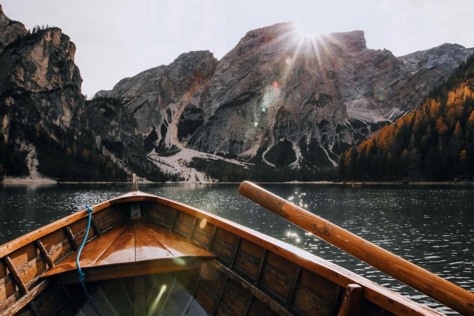 brown canoe in the body of water near mountain